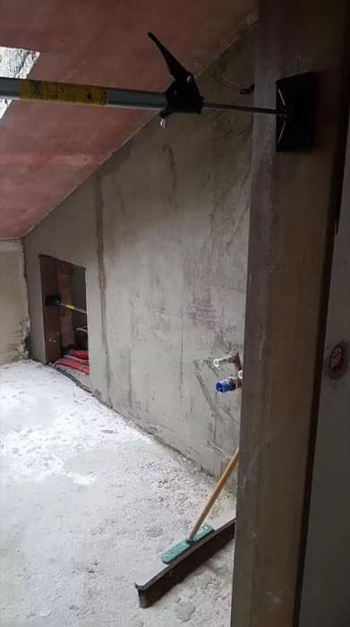 Interior desfăcut până la beton, cu planșeul sprijinit pe un timp metalic reglabil