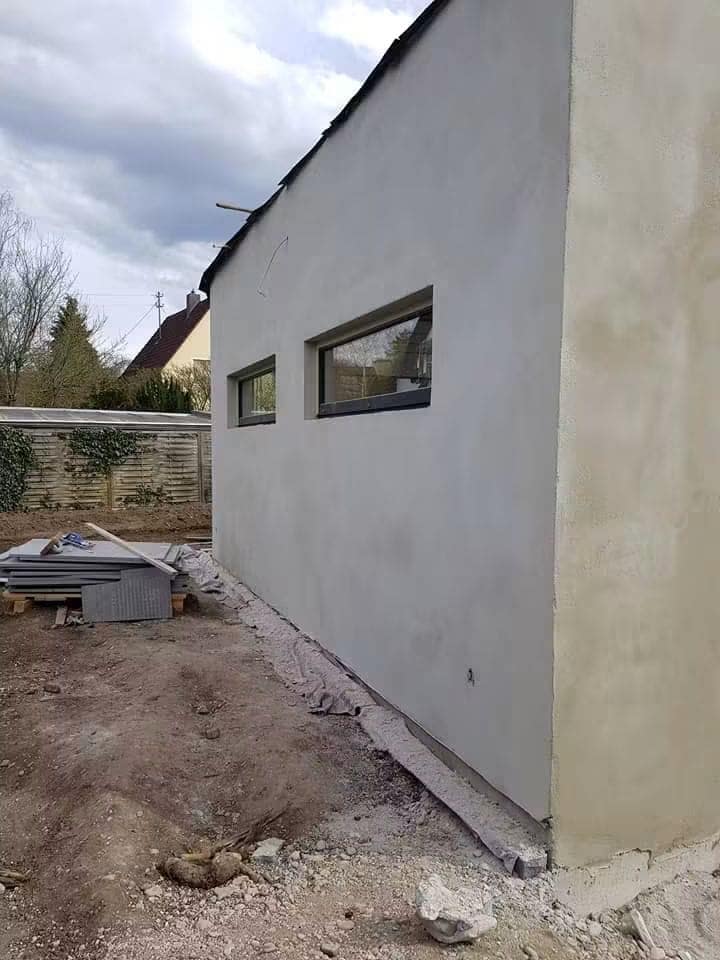 Fațadă laterală tencuită uniform, cu muchia dreaptă și golurile de fereastră finisate pe contur